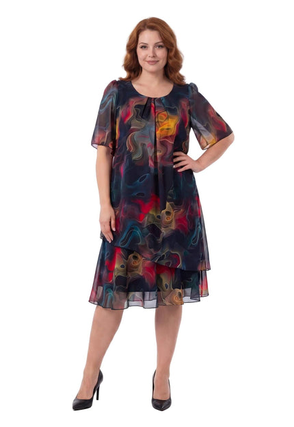 Ολόσωμη λήψη σε λευκό φόντο. Επίσημο καλοκαιρινό φόρεμα plus size από σιφόν, με πολύχρωμο αφηρημένο μοτίβο και ασύμμετρο τελείωμα.