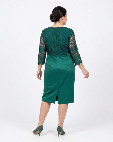 Επίσημο λαδί φόρεμα με δαντέλα μεγάλα μεγέθη, σε ολόσωμη λήψη από την πίσω πλευρά που αναδεικνύει τη δαντελωτή πλάτη και το διακριτικό άνοιγμα στο τελείωμα.