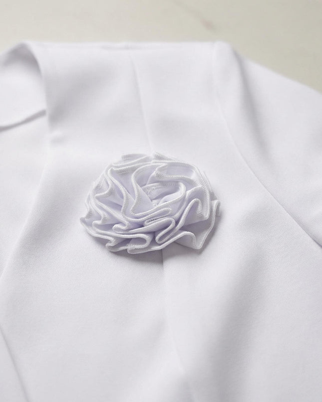 Κοντινή λεπτομέρεια της υφασμάτινης καρφίτσας τριαντάφυλλο στο πέτο, από το επίσημο λευκό σακάκι σε μεγάλα μεγέθη.