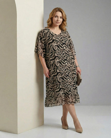 Κομψό φόρεμα από σιφόν σε μεγάλα μεγέθη με μοντέρνο μαύρο print, άνετη εβαζέ γραμμή και φαρδιά μανίκια, σε ολόσωμη εμφάνιση.