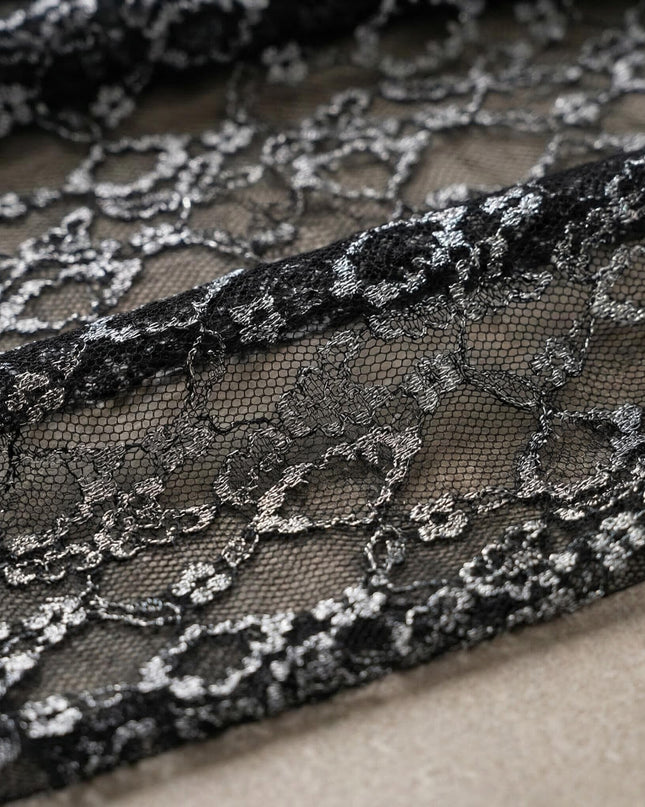 Κοντινή λεπτομέρεια από την εντυπωσιακή διάφανη δαντέλα με μεταλλική λάμψη για το επίσημο μαύρο φόρεμα σε μεγάλα μεγέθη.