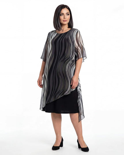 Επίσημο μαύρο φόρεμα plus size σε ολόσωμη λήψη, με ασύμμετρη αέρινη μουσελίνα και ιδιαίτερο ντεγκραντέ μοτίβο σε λευκό φόντο.