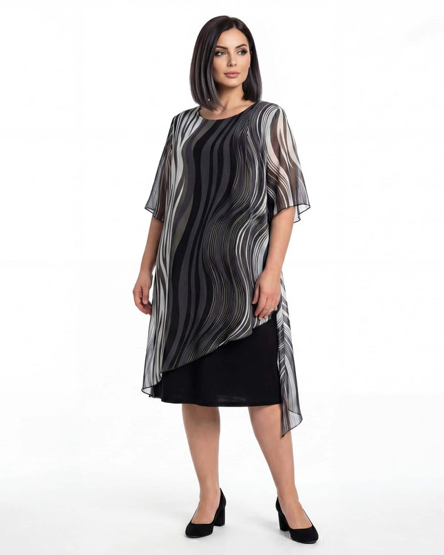 Επίσημο μαύρο φόρεμα plus size σε ολόσωμη λήψη, με ασύμμετρη αέρινη μουσελίνα και ιδιαίτερο ντεγκραντέ μοτίβο σε λευκό φόντο.