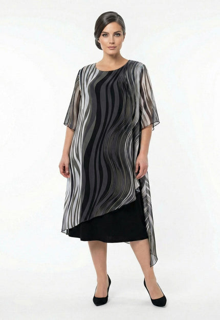 Επίσημο μαύρο φόρεμα plus size σε ολόσωμη λήψη, με αέρινη ασύμμετρη μουσελίνα και ντεγκραντέ κυματιστό σχέδιο σε γκρι και λευκούς τόνους.