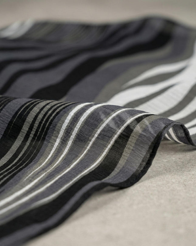 Κοντινή λεπτομέρεια της υφής από την αέρινη μουσελίνα με ντεγκραντέ σχέδιο σε μαύρο και γκρι, μέρος του επίσημου φορέματος plus size.