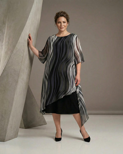 Επίσημο μαύρο φόρεμα plus size σε ολόσωμη λήψη, με ασύμμετρη μουσελίνα και ντεγκραντέ μοτίβο σε μαύρους και γκρι τόνους.