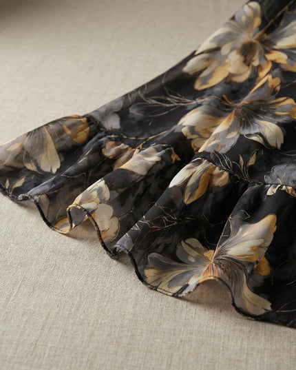 Κοντινή λεπτομέρεια στο βολάν του τελειώματος από επίσημο μαύρο φόρεμα σιφόν με φλοράλ σχέδιο, ιδανικό για μεγάλα μεγέθη.