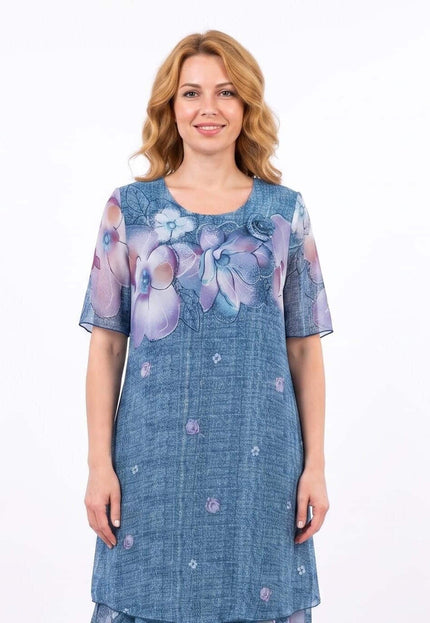 Επίσημο μπλε plus size φόρεμα με φλοράλ μοτίβο στο πάνω μέρος και αέρινο σιφόν. Μπροστινή όψη, διακρίνεται η ροζέτα στον ώμο και η άνετη εφαρμογή.