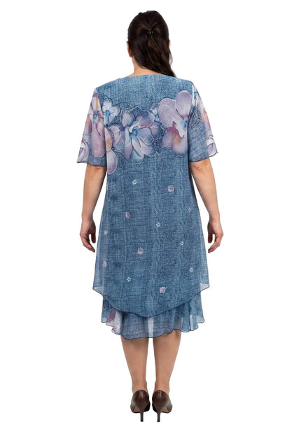 Πίσω όψη από επίσημο μπλε φλοράλ φόρεμα plus size. Διακρίνεται το αέρινο εξωτερικό από σιφόν και το πολυεπίπεδο ασύμμετρο τελείωμα.