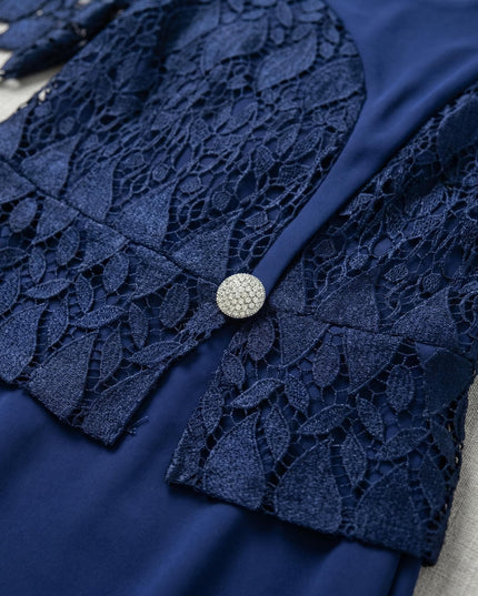 Κοντινή λεπτομέρεια από επίσημο μπλε φόρεμα plus size, εστιάζοντας στο μπούστο με την περίτεχνη δαντέλα και τη λαμπερή διακοσμητική καρφίτσα.