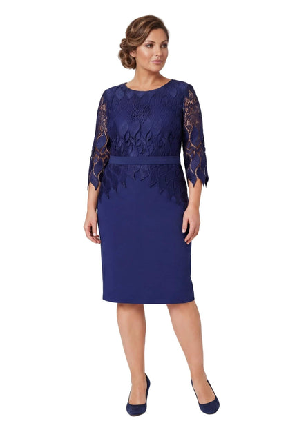 Επίσημο μπλε σκούρο φόρεμα με δαντέλα και ζώνη, ιδανικό για μεγάλα μεγέθη. Ολόσωμη λήψη του φορέματος σε λευκό φόντο.