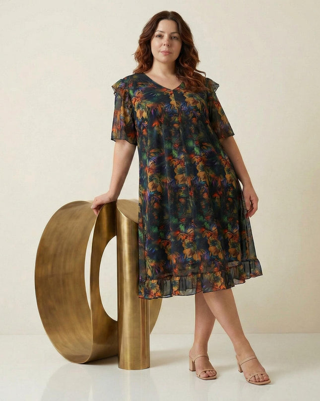 Ολόσωμη λήψη από επίσημο plus size φόρεμα σε εβαζέ γραμμή, κατασκευασμένο από χρωματιστό σιφόν με εντυπωσιακά μανίκια και βολάν στο τελείωμα.