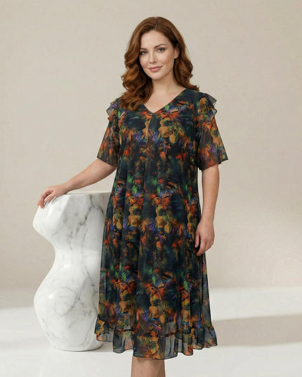 Επίσημο plus size φόρεμα από χρωματιστό σιφόν με εμπριμέ μοτίβο, V λαιμόκοψη και αέρινα μανίκια βολάν σε ολόσωμη λήψη.