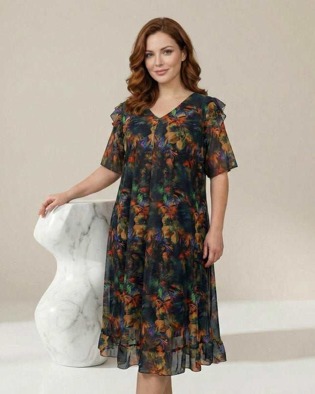 Επίσημο plus size φόρεμα από χρωματιστό σιφόν με εμπριμέ μοτίβο, V λαιμόκοψη και αέρινα μανίκια βολάν σε ολόσωμη λήψη.