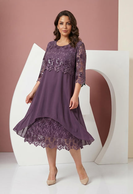 Ολόσωμη λήψη. Επίσημο plus size φόρεμα με ανάγλυφη δαντέλα, λαμπερές παγιέτες στο μπούστο, 3/4 μανίκια και ασύμμετρο τελείωμα από αέρινο σιφόν.
