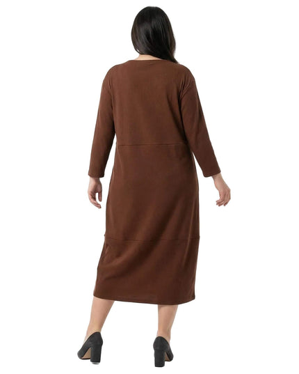 Ολόσωμη λήψη από πίσω: Καφέ μάξι φόρεμα σε μεγάλα μεγέθη. Αναδεικνύεται η άνετη εφαρμογή και τα μανίκια 7/8 σε λευκό φόντο.