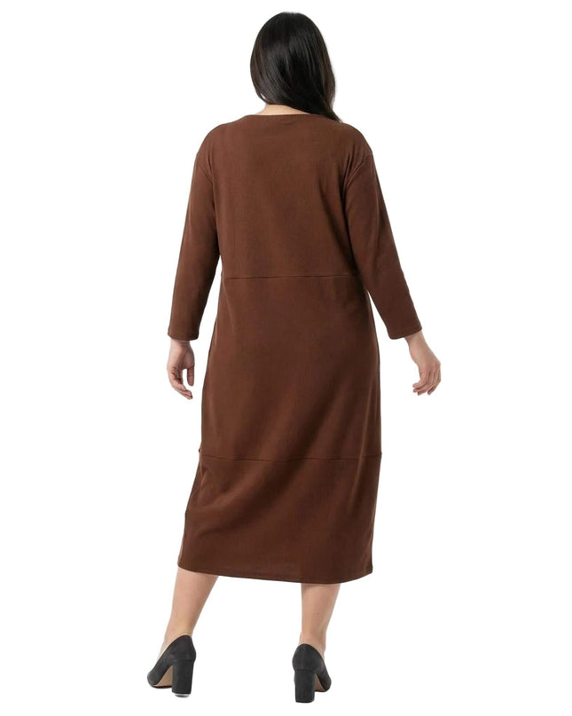 Ολόσωμη λήψη από πίσω: Καφέ μάξι φόρεμα σε μεγάλα μεγέθη. Αναδεικνύεται η άνετη εφαρμογή και τα μανίκια 7/8 σε λευκό φόντο.