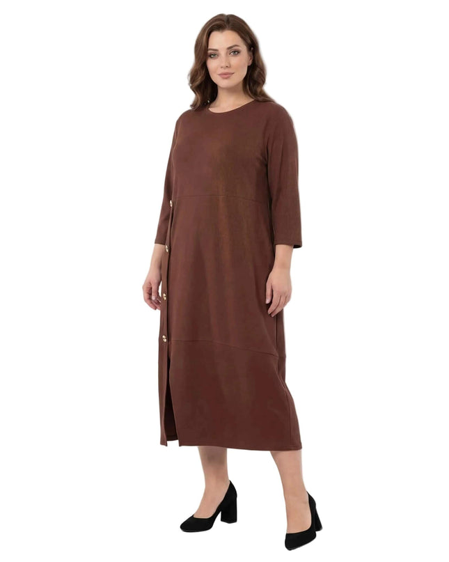 Ολόσωμη λήψη σε λευκό φόντο: Επίσημο plus size μάξι φόρεμα σε καφέ χρώμα με στρογγυλή λαιμόκοψη, μανίκια 7/8 και διακοσμητικά χρυσά κουμπιά μπροστά.