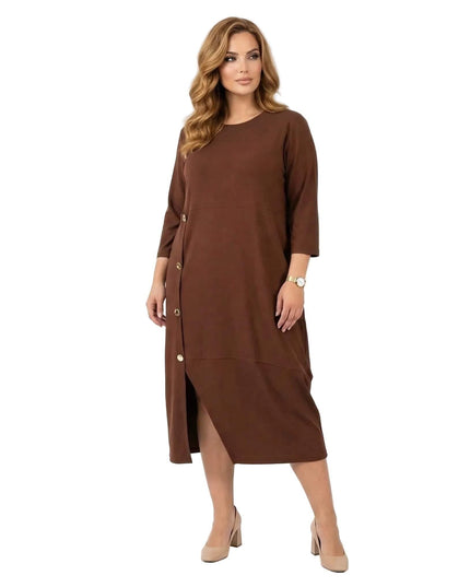 Ολόσωμη λήψη: Επίσημο plus size μάξι φόρεμα σε ζεστό καφέ χρώμα με στρογγυλή λαιμόκοψη και εντυπωσιακά χρυσά κουμπιά στο πλάι, σε λευκό φόντο.