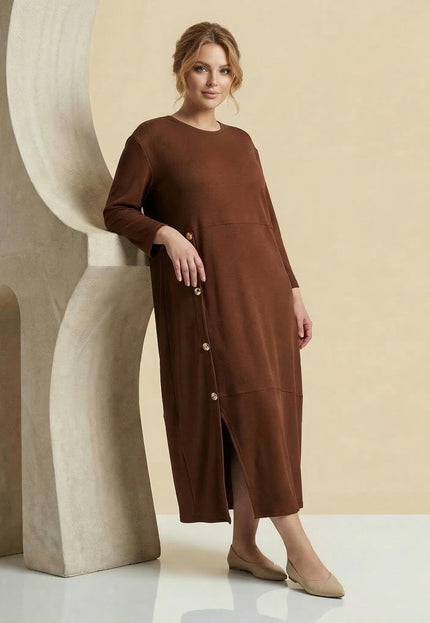 Ολόσωμη λήψη: Επίσημο καφέ plus size μάξι φόρεμα με ριπ υφή, μανίκια 7/8, διακοσμητικά χρυσά κουμπιά και σκίσιμο.