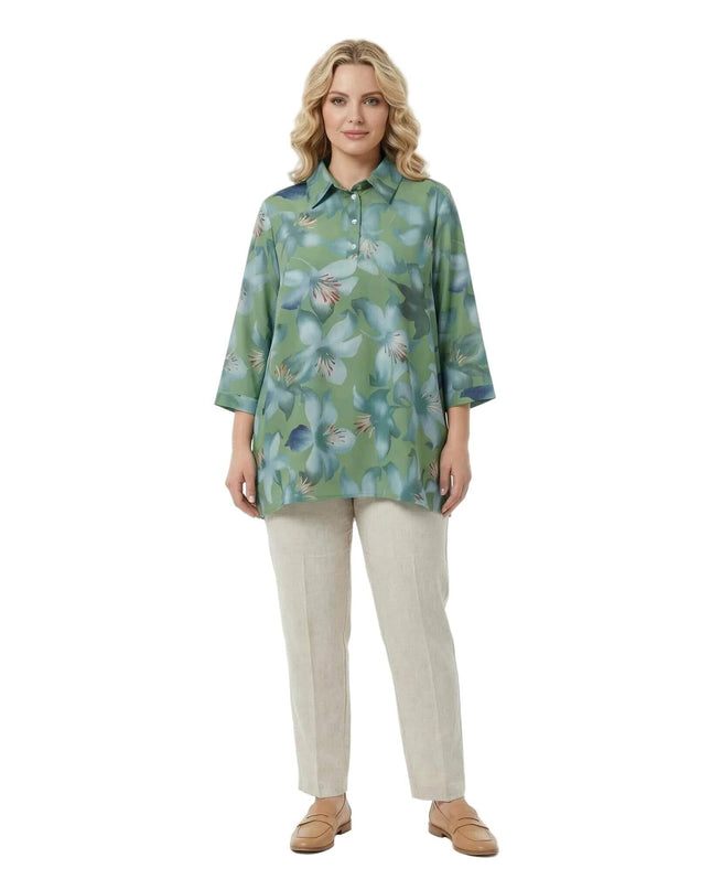 Ολόσωμη λήψη με λευκό φόντο. Πράσινο φλοράλ πουκάμισο σε μεγάλα μεγέθη με εβαζέ γραμμή και 7/8 μανίκια, συνδυασμένο με μπεζ παντελόνι.
