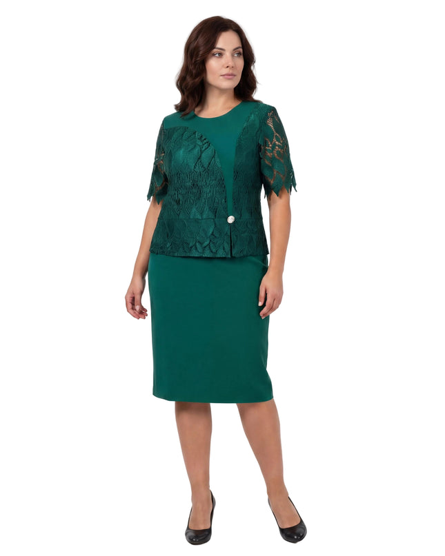 Επίσημο πράσινο φόρεμα με δαντέλα στο μπούστο και διακριτική καρφίτσα σε μεγάλα μεγέθη, παρουσιασμένο σε ολόσωμη λήψη σε λευκό φόντο.