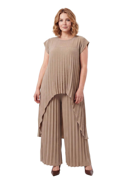 Ολόσωμη λήψη σε λευκό φόντο. Επίσημο σετ plus size με φαρδιά παντελόνα και πλισέ τουνίκ σε καφέ χρώμα και ασύμμετρο τελείωμα.