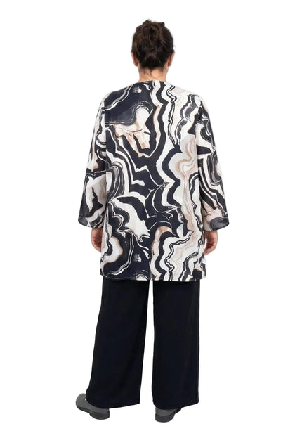 Πίσω όψη από επίσημο plus size σετ τριών τεμαχίων, με μαύρη παντελόνα και εντυπωσιακή πελέρινα με μαρμάρινο μοτίβο, σε λευκό φόντο.