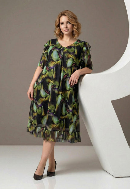Επίσημο σιφόν φόρεμα plus size με πολύχρωμο μοτίβο και βολάν στο τελείωμα. Ολόσωμη λήψη που αναδεικνύει την αέρινη γραμμή και τα κομψά μανίκια.