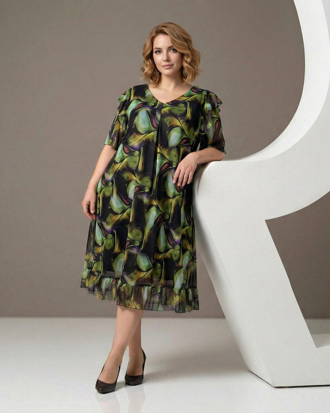 Επίσημο σιφόν φόρεμα plus size με πολύχρωμο μοτίβο και βολάν στο τελείωμα. Ολόσωμη λήψη που αναδεικνύει την αέρινη γραμμή και τα κομψά μανίκια.