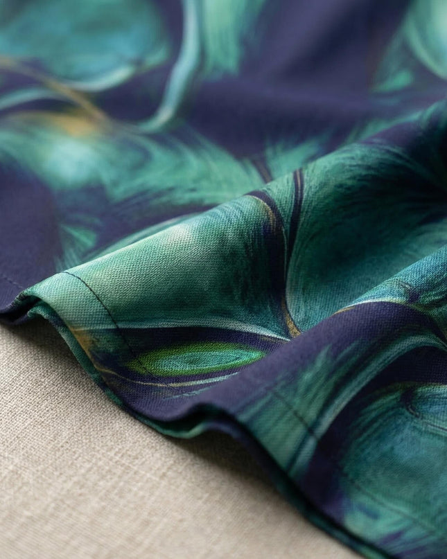 Κοντινή λεπτομέρεια υφάσματος από επίσημο σιφόν φόρεμα σε μεγάλα μεγέθη, που αναδεικνύει το αφηρημένο print σε ντεγκραντέ μπλε και πράσινες αποχρώσεις.