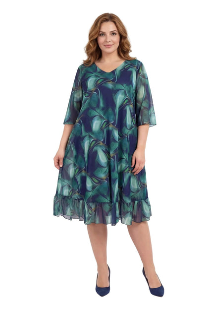 Μπροστινή ολόσωμη λήψη. Επίσημο σιφόν φόρεμα σε μεγάλα μεγέθη με ντεγκραντέ μπλε-πράσινο μοτίβο, V-ντεκολτέ και βολάν στο τελείωμα.