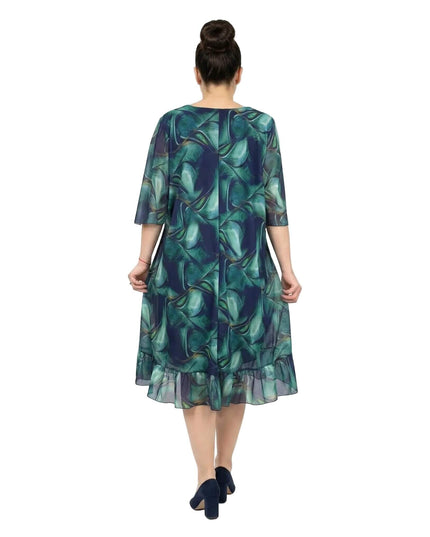 Πίσω όψη: Επίσημο σιφόν φόρεμα σε μεγάλα μεγέθη, με εντυπωσιακό μπλε-πράσινο ντεγκραντέ μοτίβο και κομψό βολάν στο τελείωμα, σε λευκό φόντο.