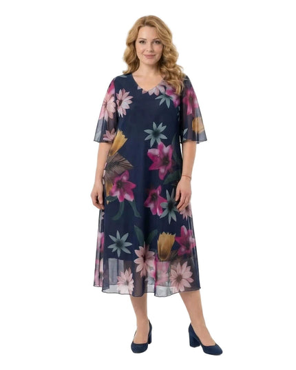 Ολόσωμη λήψη σε λευκό φόντο: Επίσημο σκούρο μπλε φόρεμα σε μεγάλα μεγέθη, με φλοράλ σχέδια σε σιφόν ύφασμα, V-λαιμόκοψη και αέρινα μανίκια.