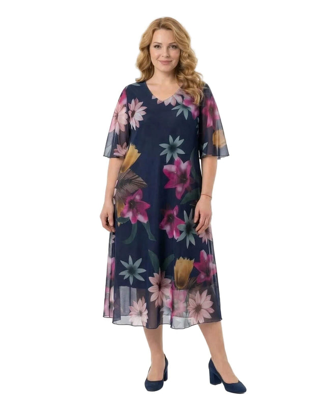 Ολόσωμη λήψη σε λευκό φόντο: Επίσημο σκούρο μπλε φόρεμα σε μεγάλα μεγέθη, με φλοράλ σχέδια σε σιφόν ύφασμα, V-λαιμόκοψη και αέρινα μανίκια.