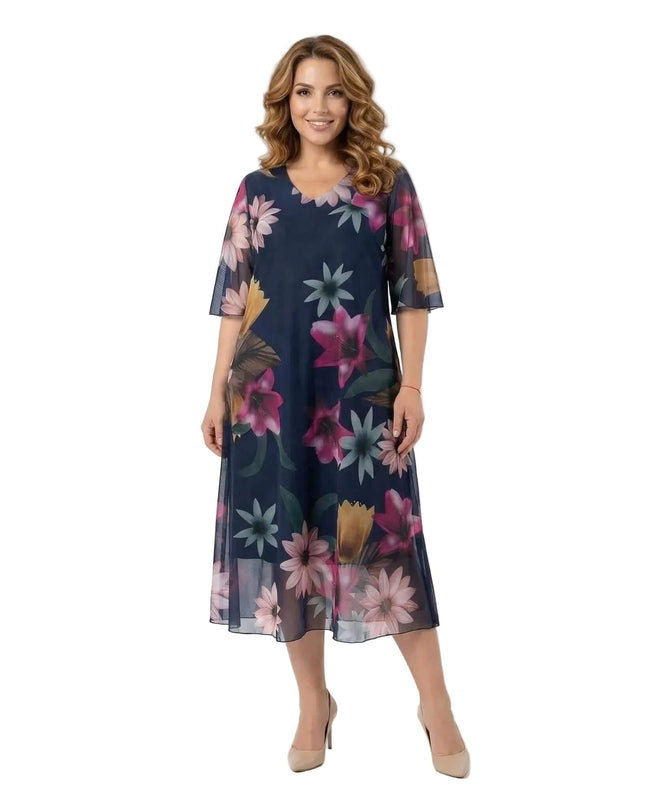 Επίσημο σκούρο μπλε φόρεμα σε μεγάλα μεγέθη με αέρινο φλοράλ σιφόν και V-λαιμόκοψη. Ολόσωμη λήψη σε λευκό φόντο που αναδεικνύει την εβαζέ γραμμή.