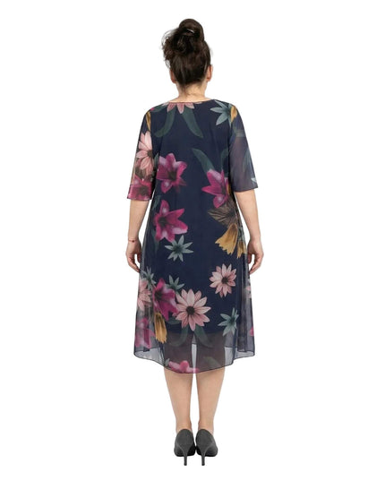 Πίσω όψη από επίσημο σκούρο μπλε φόρεμα σε μεγάλα μεγέθη. Αναδεικνύεται το φλοράλ σιφόν ύφασμα, η εβαζέ γραμμή και τα ημιδιάφανα μανίκια.