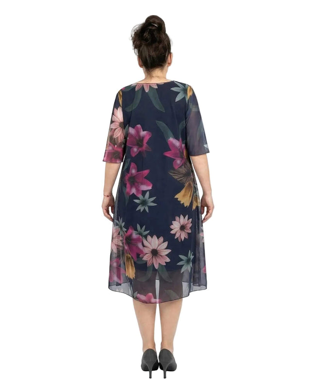 Πίσω όψη από επίσημο σκούρο μπλε φόρεμα σε μεγάλα μεγέθη. Αναδεικνύεται το φλοράλ σιφόν ύφασμα, η εβαζέ γραμμή και τα ημιδιάφανα μανίκια.