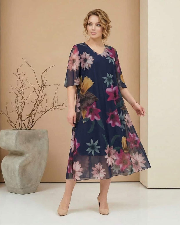 Γυναίκα φοράει floral φόρεμα σε στούντιο και παρουσιάζει επίσημο ντύσιμο για μεγάλα μεγέθη