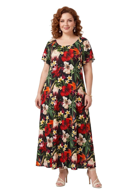 Ολόσωμη λήψη σε λευκό φόντο με floral μάξι φόρεμα σε μεγάλα μεγέθη, με εντυπωσιακό τροπικό μοτίβο και κοντά μανίκια.