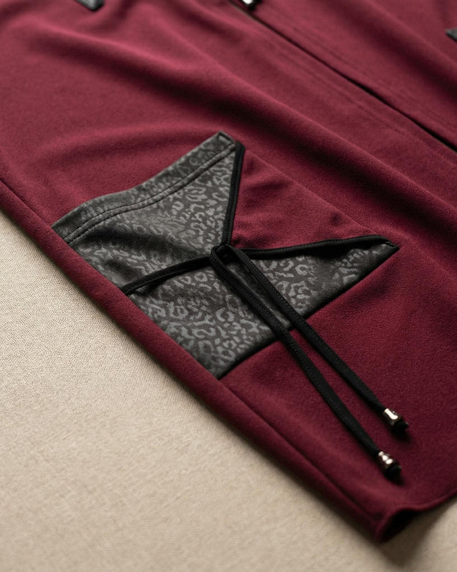 Κοντινή λεπτομέρεια τσέπης σε μπορντό γιλέκο μεγάλα μεγέθη, με καπάκι από ανάγλυφη δερματίνη σε μοτίβο animal print και κορδόνια με μεταλλικά τελειώματα.