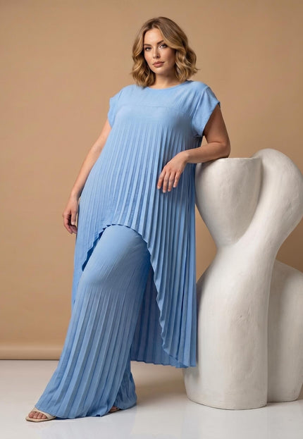 Ολόσωμη λήψη με γαλάζιο επίσημο σετ plus size, που περιλαμβάνει ασύμμετρη πλισέ τουνίκ και φαρδιά παντελόνα. Ιδανική εφαρμογή για καμπύλες.