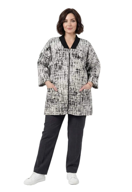 Ολόσωμη λήψη σε λευκό φόντο: γυναικεία plus size ζακέτα σε μπεζ απόχρωση με αφηρημένο μαύρο σχέδιο, φερμουάρ και πρακτικές τσέπες.
