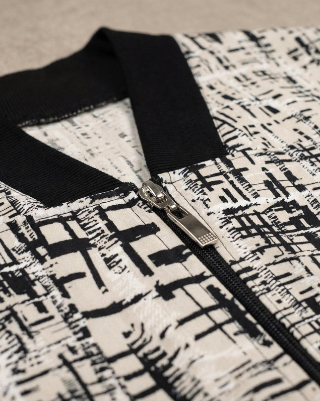 Κοντινή λεπτομέρεια σε γυναικεία plus size ζακέτα. Διακρίνεται το ασημένιο φερμουάρ, ο μαύρος ριμπ γιακάς V και το μπεζ ύφασμα με αφηρημένο σχέδιο.