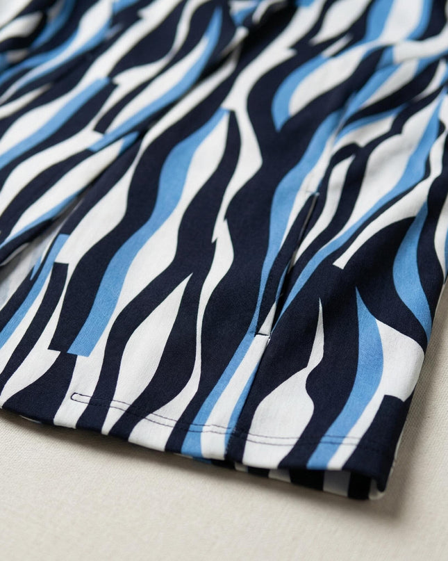 Κοντινή λεπτομέρεια του υφάσματος από γυναικείο σακάκι σε μεγάλα μεγέθη, που αναδεικνύει το τελείωμα και τα αφηρημένα μπλε και μαύρα μοτίβα.