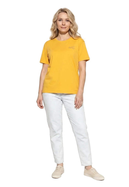 Γυναικείο κίτρινο βαμβακερό t-shirt σε μεγάλα μεγέθη. Ολόσωμη λήψη της μπροστινής όψης σε λευκό φόντο, φορεμένο με ανοιχτόχρωμο τζιν.