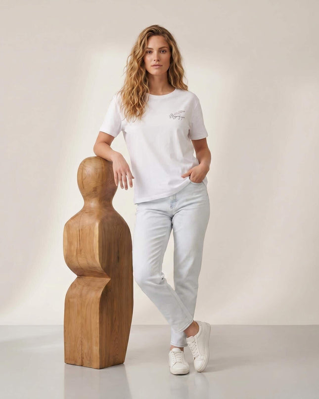 Ολόσωμη λήψη: Γυναικείο λευκό βαμβακερό T-shirt σε μεγάλα μεγέθη. Διαθέτει στρογγυλή λαιμόκοψη, κοντό μανίκι και διακριτικό σχέδιο στο στήθος.