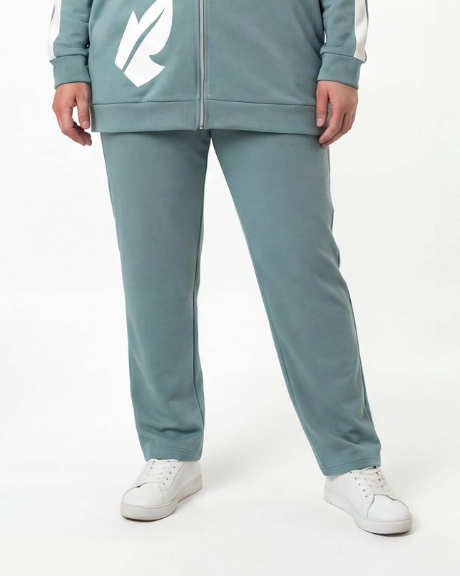 Γυναικείο plus size σετ σε ανοιχτό πράσινο, λήψη που εστιάζει στην άνετη εφαρμογή του παντελονιού και στη λευκή λεπτομέρεια της ζακέτας.