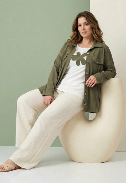 Γυναικείο σετ δύο τεμαχίων plus size που αποτελείται από χακί σακάκι και λευκό t-shirt με μεγάλη στάμπα, σε καθιστή ολόσωμη λήψη.