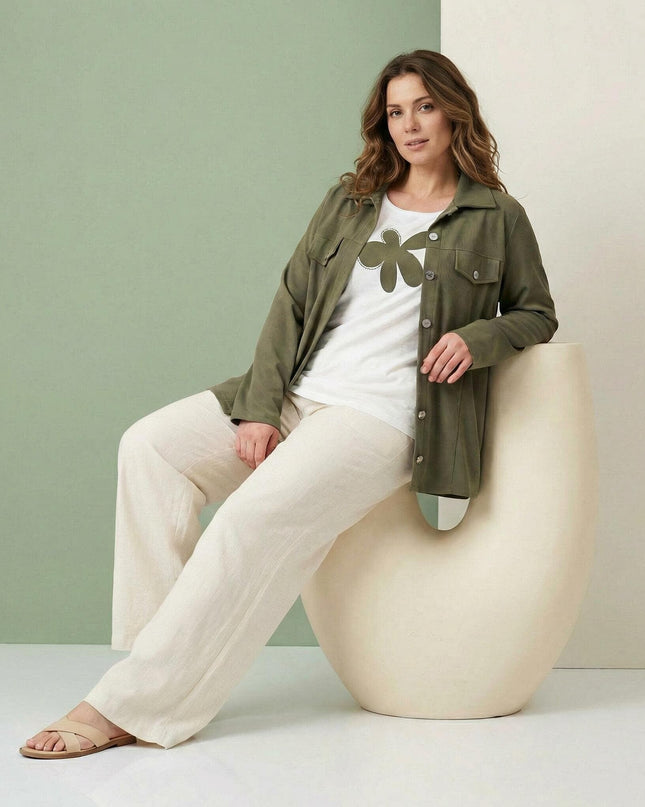 Γυναικείο σετ δύο τεμαχίων plus size που αποτελείται από χακί σακάκι και λευκό t-shirt με μεγάλη στάμπα, σε καθιστή ολόσωμη λήψη.